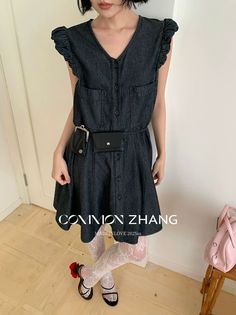Woman in a denim dress and white lace tights with a belt bag
