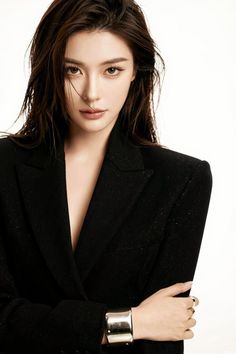 Woman with wet hair wearing a black blazer with a deep V neck and a silver cuff