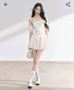 Woman in a white off-shoulder mini dress and mary jane shoes indoors