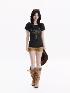 Woman with black hair wearing a dark t-shirt, short shorts, and cowboy boots