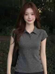 Woman with long brown hair wearing a dark grey polo shirt outdoors