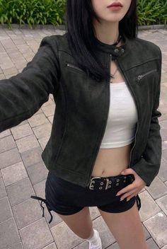 Person in a black jacket and white crop top with exposed midriff outdoors