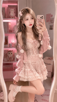 Woman in a pink lace dress and cardigan taking a mirror selfie