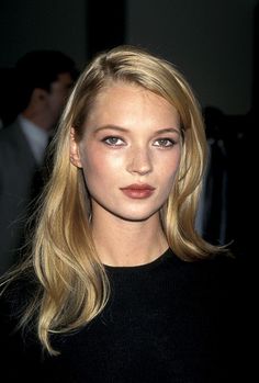 Woman with blonde hair wearing a black top, captured in a soft-lit portrait