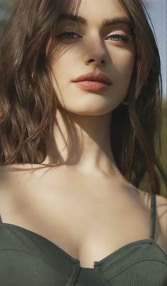 Woman with long hair and green eyes in soft lighting, upper body portrait