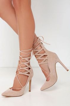 Pair of nude lace-up high heels with stiletto heels on a white background