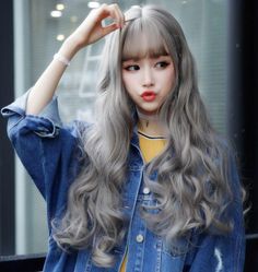 Woman with long wavy blonde hair wearing a denim jacket and choker