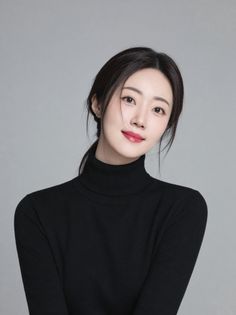 Woman with a ponytail wearing a black turtleneck in a studio setting