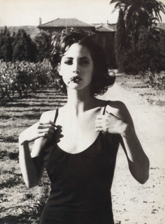 Woman with short curly hair in a black top in a vineyard