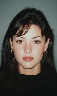 Woman with long dark hair and brown eyes wearing earrings