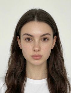 Woman with long dark hair and freckles wearing a white t-shirt