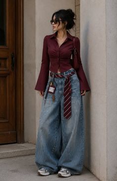 Woman in a maroon shirt and baggy jeans with a tie as a belt