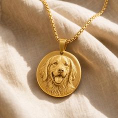 Gold pendant with a detailed portrait of a golden retriever on a light fabric