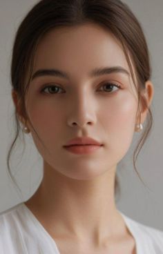 Close-up portrait of a woman with brown hair and pearl earrings
