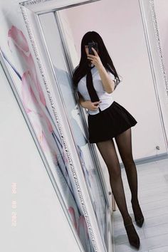 Woman in a school uniform taking a mirror selfie