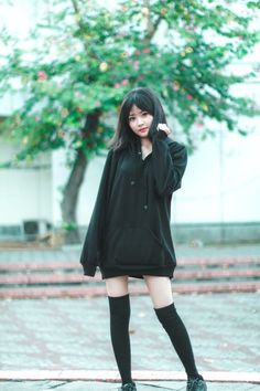 Young woman in a black hoodie and thigh high socks outdoors