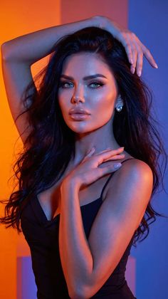 Woman with long dark hair in a black dress with dramatic lighting