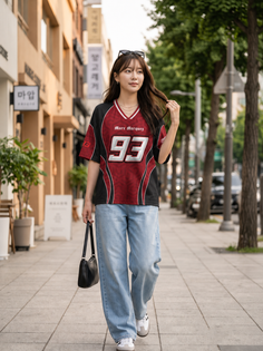 Woman in an oversized jersey and loose jeans walking on a city street