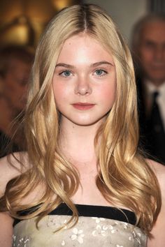 Young woman with long blonde hair and blue eyes wearing a strapless floral dress