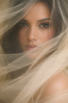 Close up portrait of a woman with brown eyes, partially covered by sheer fabric