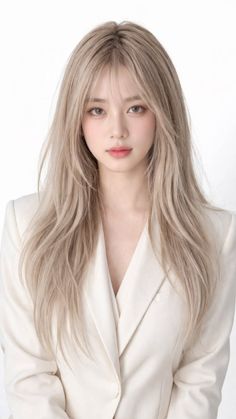 Woman with long blonde hair wearing a white blazer, looking directly at the camera