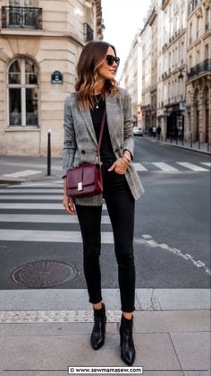Woman in a plaid blazer and black jeans with a shoulder bag on a city street
