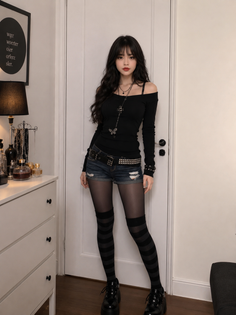 Woman with long black hair in an off-shoulder top, denim shorts, and striped stockings