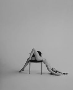 Woman in lingerie posing on a chair in a studio, black and white photograph
