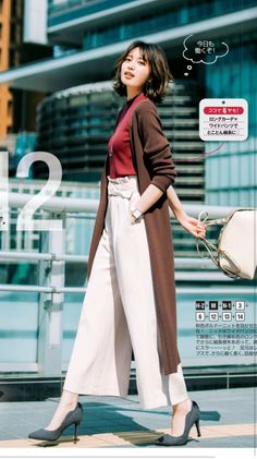 Woman in a long brown cardigan and wide leg pants walking outdoors