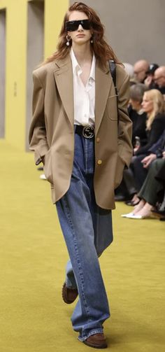Runway model in an oversized blazer, wide leg jeans, and sunglasses