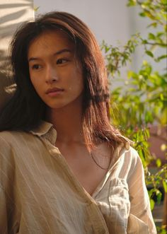 Woman with long hair in a striped shirt outdoors during golden hour
