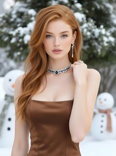 Woman with long red hair and blue eyes wearing a strapless dress in a winter scene