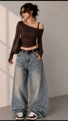 Woman in an off-shoulder top and baggy jeans with a chain accessory