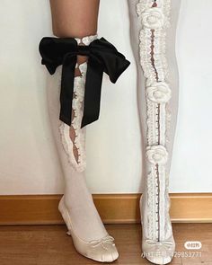Legs wearing white stockings with lace, bows, and ballet flats