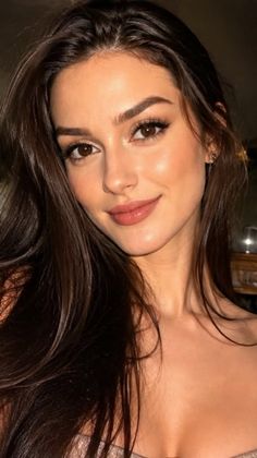 Woman with long dark hair and brown eyes smiling at the camera