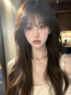 Woman with long dark hair and soft lighting indoors