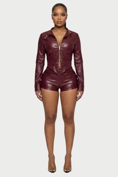 Woman in a burgundy leather jacket and shorts with high heels