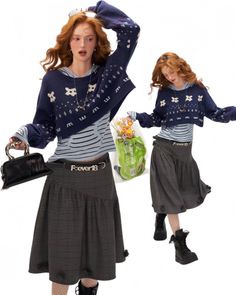 Woman with long red hair wearing a cropped sweater and plaid skirt