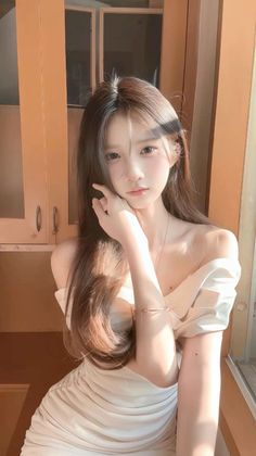 Woman with long hair in an off-shoulder dress with soft lighting indoors