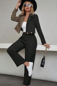 Woman in a cropped blazer with plaid sleeve, wide leg pants, and a black hat