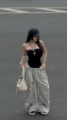Woman in a black bodysuit and oversized sweatpants on a street
