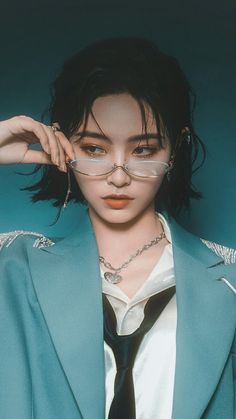 Person in a blue blazer and glasses looking directly at the viewer
