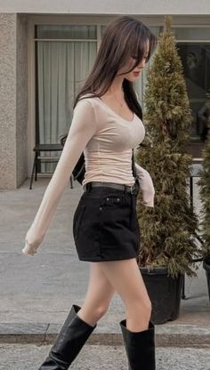 Woman with long hair wearing a black mini skirt and long sleeve top outdoors