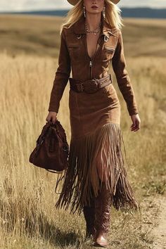 Woman in a suede dress with fringe skirt and cowboy boots walking outdoors