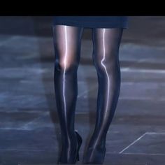 Person wearing black pantyhose, high heels, and a short skirt