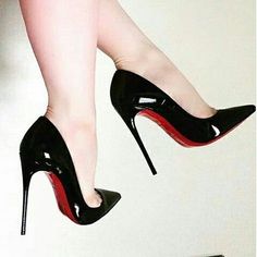 Woman's legs wearing black high heels with red soles