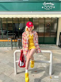 Woman with blonde hair and a red cap sitting outside a coffee shop