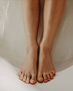 Legs and feet with water drops in a bathtub