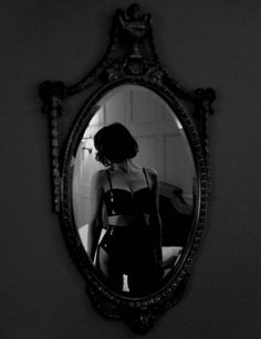 Woman in latex lingerie reflected in an ornate mirror