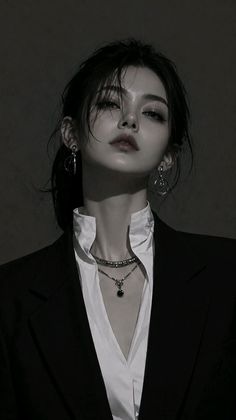 Woman in a suit and white shirt with jewelry, dark tone portrait